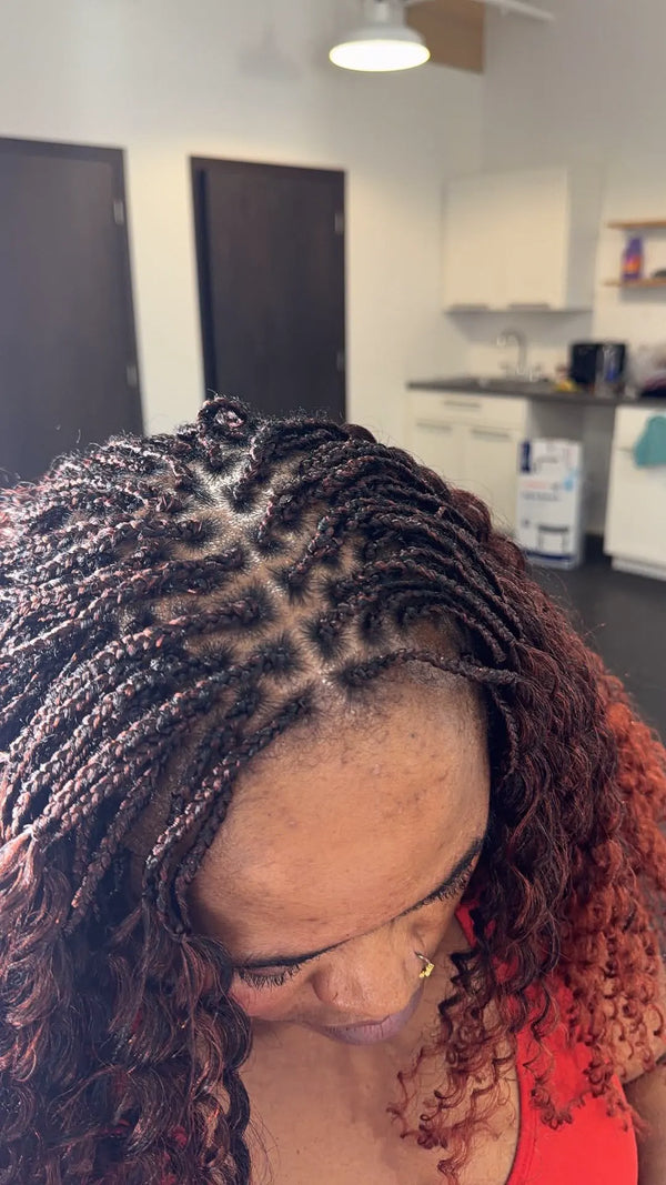 Close-up of the parting on boho braids with curly ends, braided at Lovely Hair in West Des Moines
