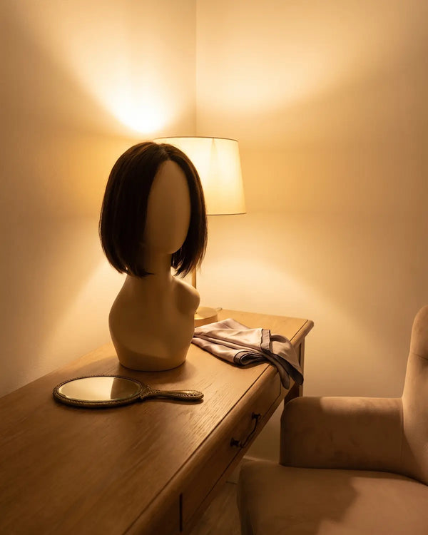 A soft short medical wig on a stand in the private fitting room at Lovely Hair, West Des Moines
